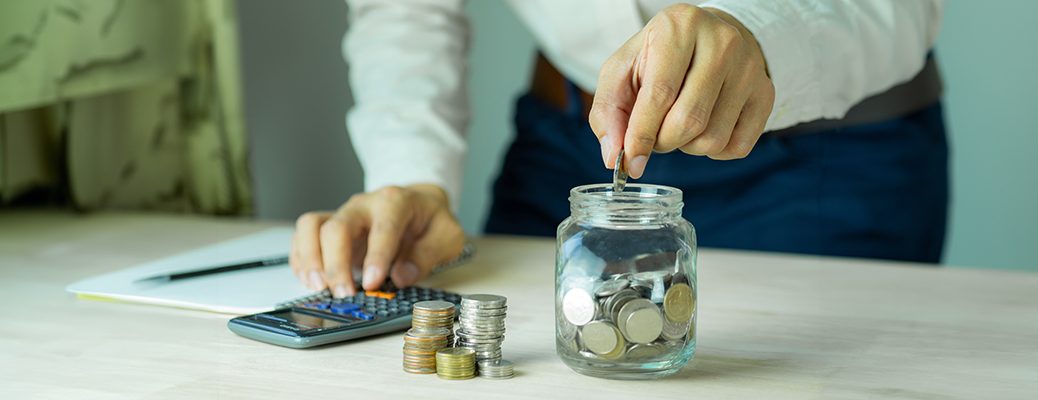 Counting coins and using a calculator shows how to leverage a savings account with IndusInd Bank to achieve financial goals.