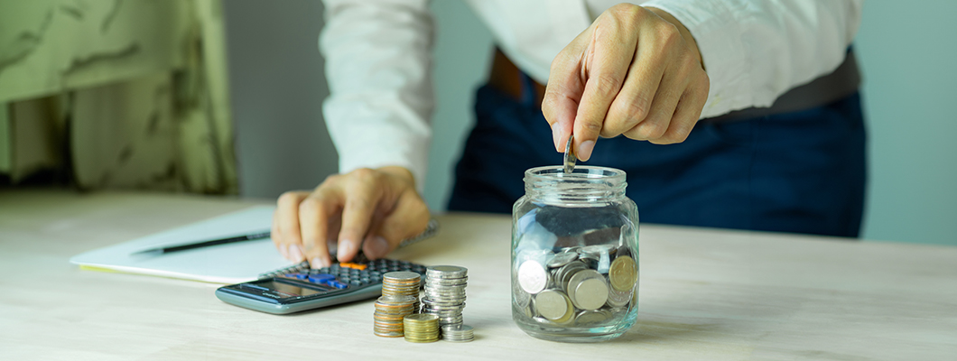 Counting coins and using a calculator shows how to leverage a savings account with IndusInd Bank to achieve financial goals.