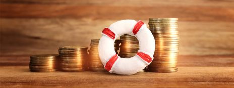 Stacks of gold coins alongside a small lifebuoy symbolizing financial security and preparedness for emergencies with IndusInd bank personal Loan
