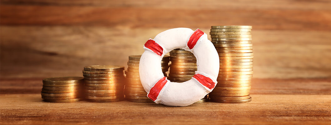 Stacks of gold coins alongside a small lifebuoy symbolizing financial security and preparedness for emergencies with IndusInd bank personal Loan