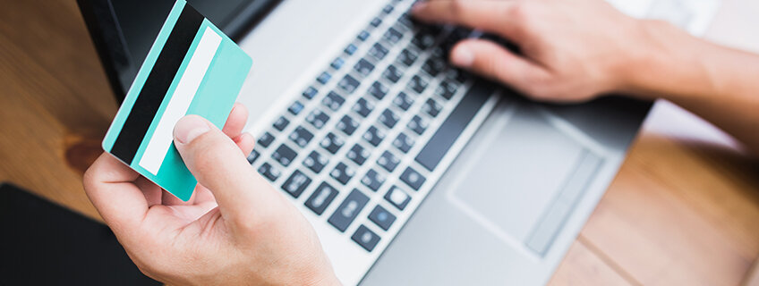 Person using IndusInd Bank credit card on a laptop, highlighting its secure CVV features for safe online transactions and fraud prevention.