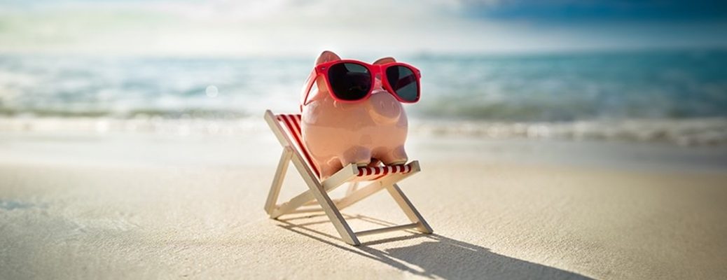 Piggy bank on beach symbolizing smart savings for travel by securing competitve interest rates for travel loan with IndusInd Bank.