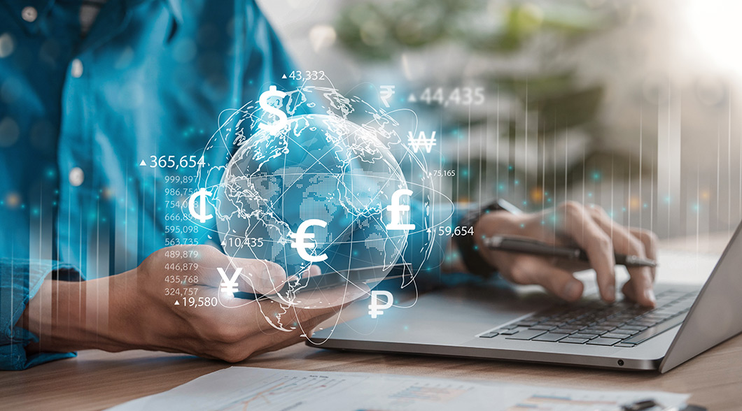 Person using a laptop with digital globe and currency symbols, comparing Forex cards and cash. Unlock seamless international travel with an IndusInd Bank forex card