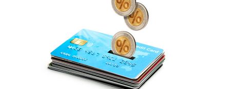 Stack of IndusInd Bank Credit Cards with coins dropping onto them symbolizing chargeback mechanism for secure transactions and dispute resolution.
