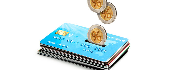 Stack of IndusInd Bank Credit Cards with coins dropping onto them symbolizing chargeback mechanism for secure transactions and dispute resolution.