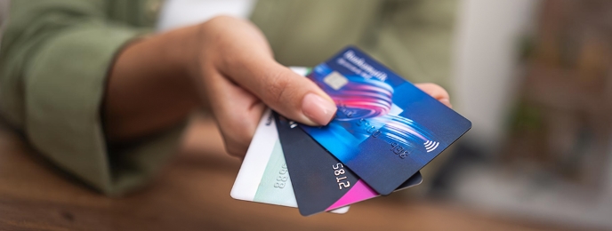 Person holding multi-currency cards, showcasing 2024's best options. Choose IndusForex card for seamless global transactions.