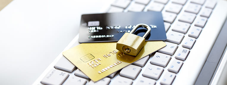 Cards and lock on a keyboard. Learn to close your card safely. Choose IndusInd Bank Credit Card for secure financial management and benefits.