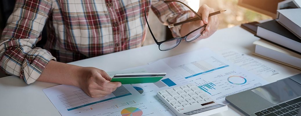 Person analyzing debt, considering IndusInd Bank's personal loan for debt consolidation based on low rates and easy process.