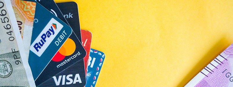 A mix of RuPay, Visa, and Mastercard cards with currency notes symbolizing list of premium credit cards offered by IndusInd Bank.