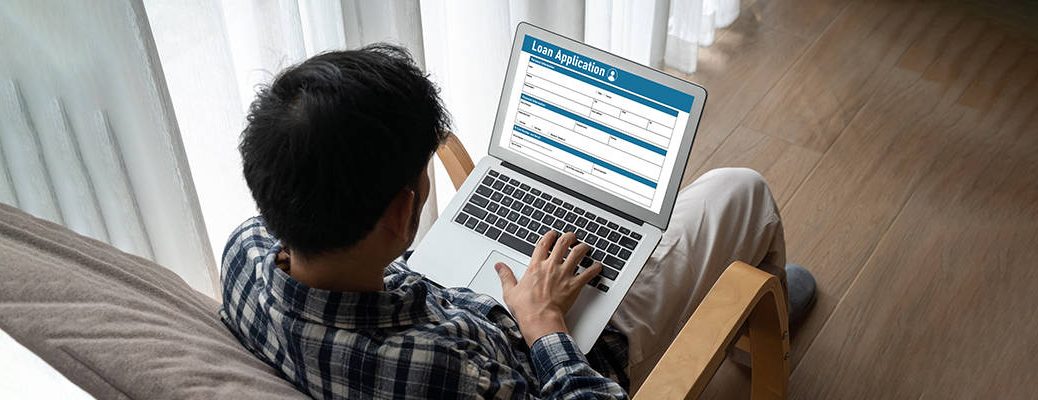 A person is using a laptop, applying to IndusInd Bank Personal loan form easily and with convenience to secure their future.