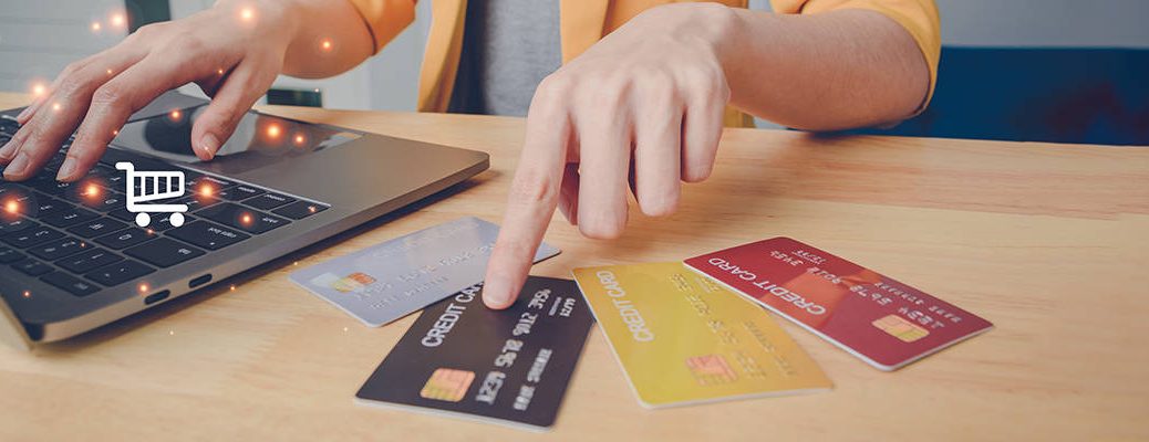 Person using laptop and IndusInd Bank credit card for seamless rent payment, showcasing an efficient online rent payment guide.