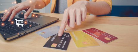 Person using laptop and IndusInd Bank credit card for seamless rent payment, showcasing an efficient online rent payment guide.