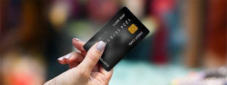 Hand holding a credit card. Discover benefits of credit card insurance with IndusInd Bank Credit Card for comprehensive protection