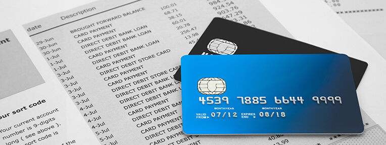 Credit cards on a bank statement, representing steps to take when addressing an incorrect credit card bill.